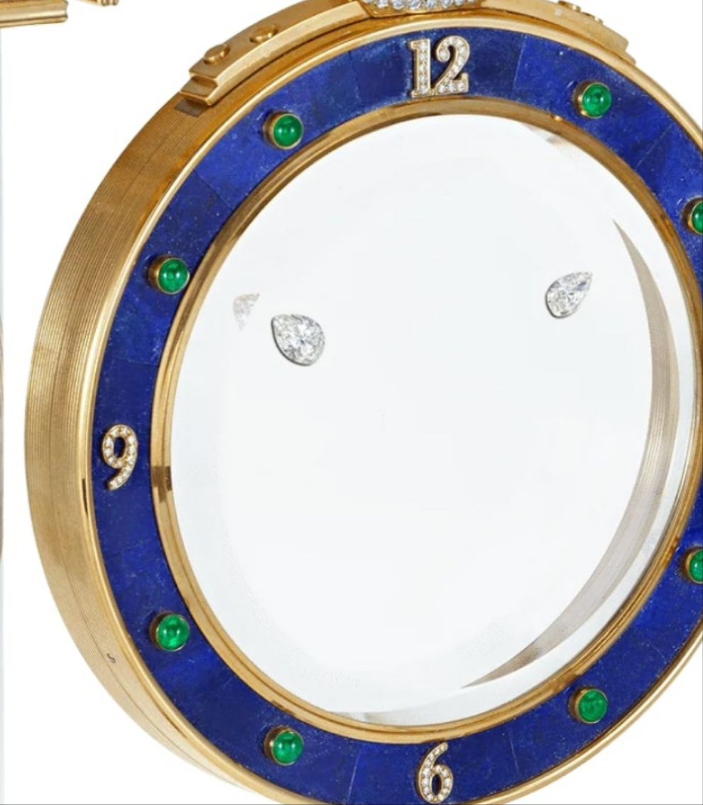 Diamond Mystery Clock Floating 2,150 grams of 18K yellow gold and it is adorned with an array of exceptional gemstones: two pear-shaped diamonds (3.02 and 1.79 carats), 49.96 carats of round-cut diamonds and 9.60 carats of cabochon emeralds.