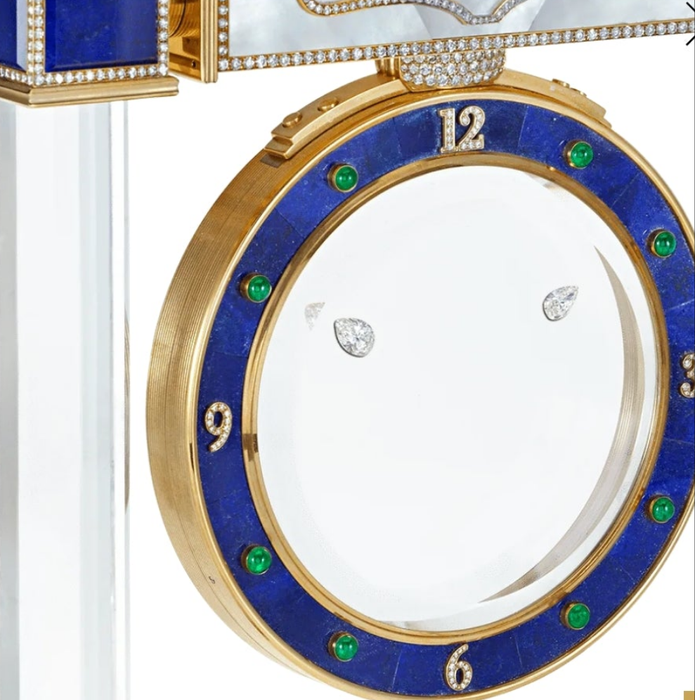 Diamond Mystery Clock Floating 2,150 grams of 18K yellow gold and it is adorned with an array of exceptional gemstones: two pear-shaped diamonds (3.02 and 1.79 carats), 49.96 carats of round-cut diamonds and 9.60 carats of cabochon emeralds.